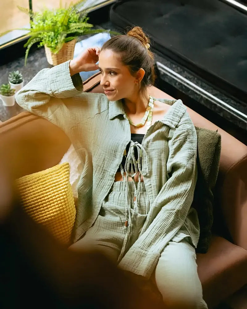 Woman in green Loungewear Set sitting on a couch in a cozy living room setting