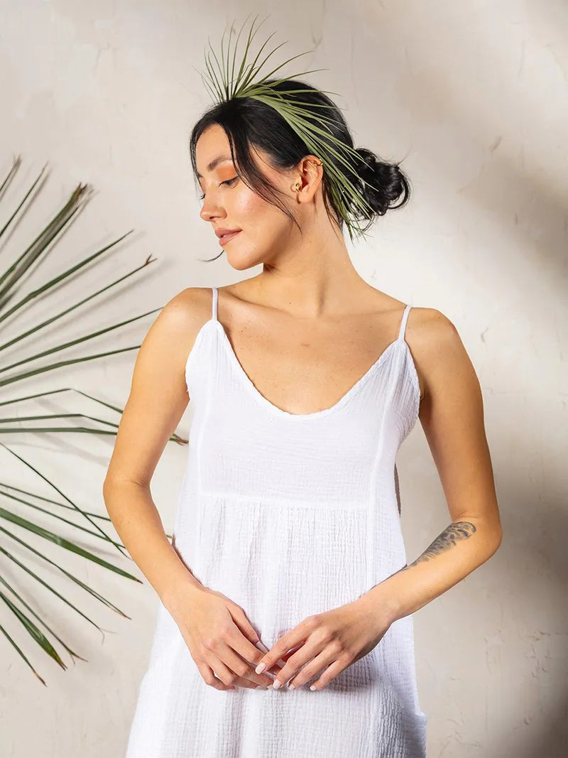 Woman wearing a white double gauze strap dress with a minimalist background