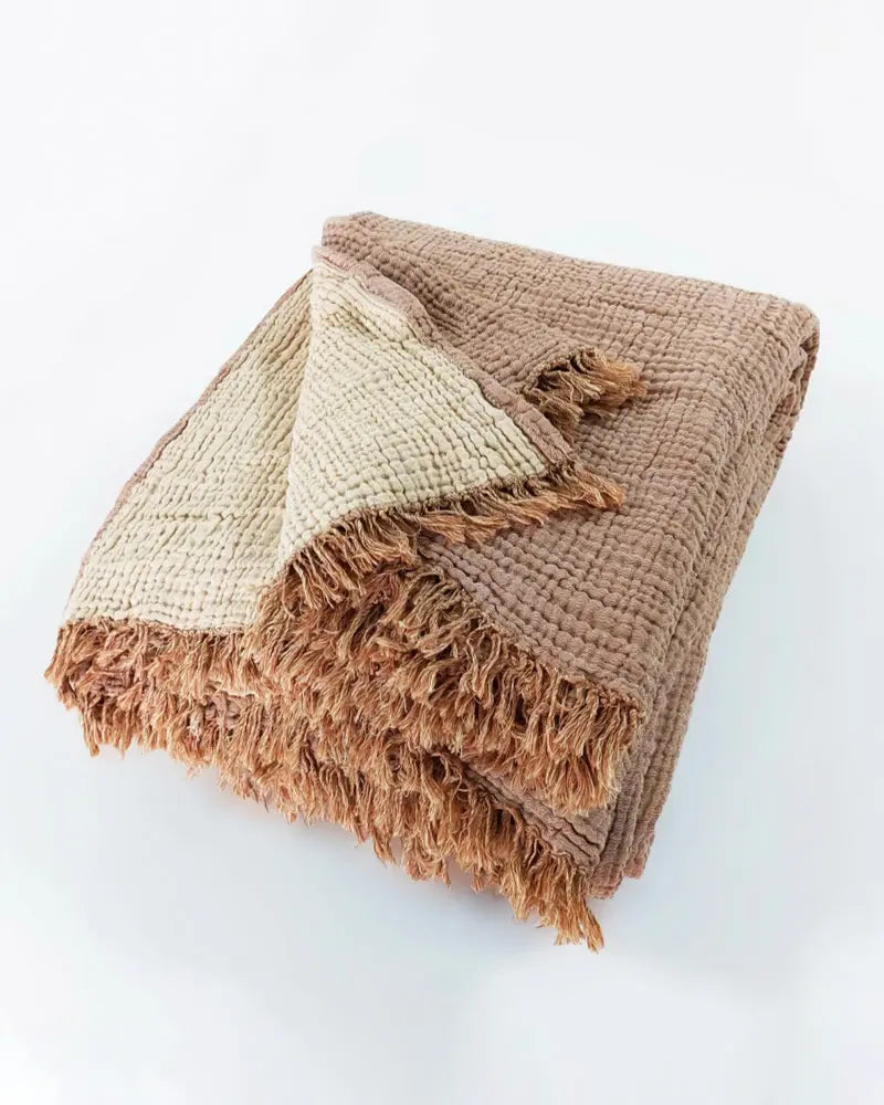 muslin blanket with frayed edges on a white background