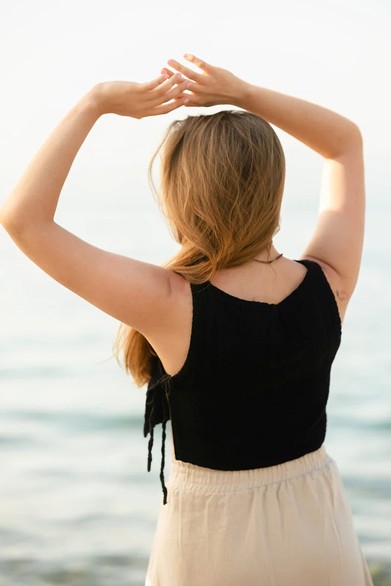 Woman with Crinkle Cotton Side Tie Crop Top arms raised by a body of water