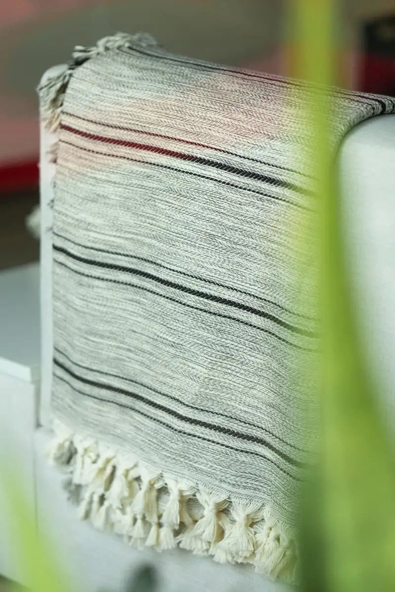 Black striped grey blanket with tassels on the sofa
