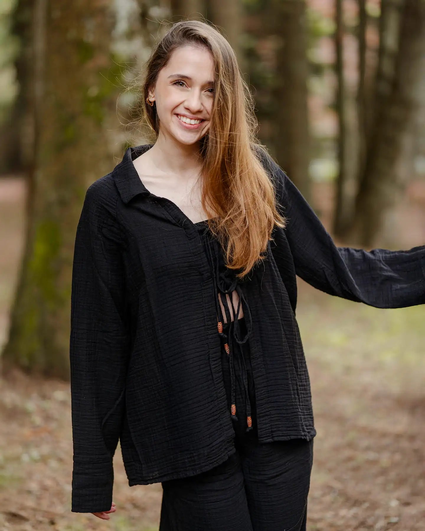 Woman wearing a black pyjama set in a forest setting