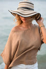 Woman in a wide-brimmed hat and brown linen top by the water — soft European Flax linen drape