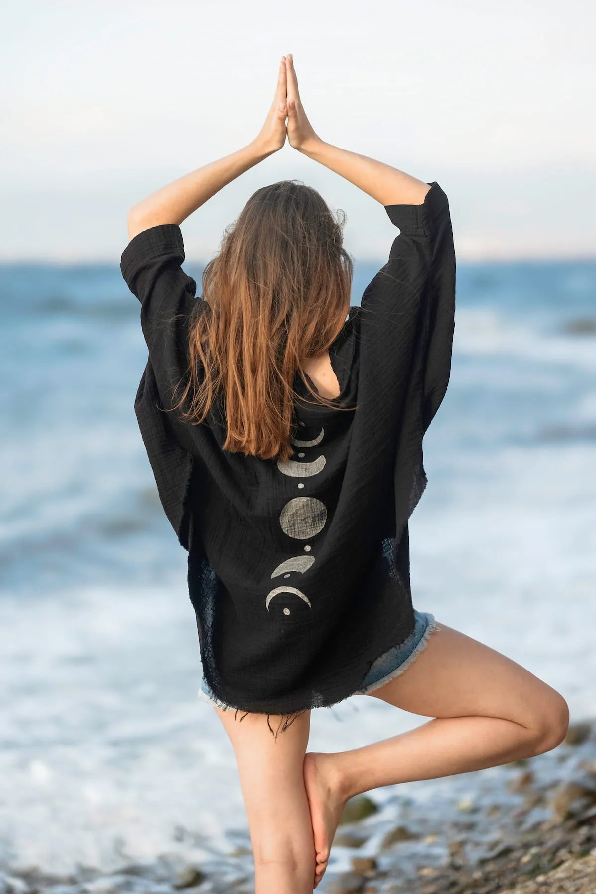 Person practicing yoga on a beach with Crinkle Cotton Silver Moon Jacket