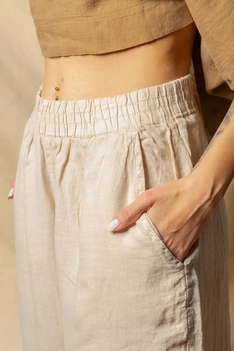 Beige linen palazzo pants worn by a person with a neutral background