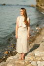 Woman in a beige linen wrap midi skirt by the water — 100% European linen, adjustable tie waist
