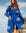 Woman wearing a blue Evil Eye Kimono robe with eye designs against a natural background