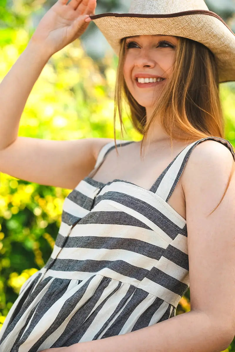 Woman wearing a Striped Linen Button Down Midi Dress and cowboy hat in a garden setting