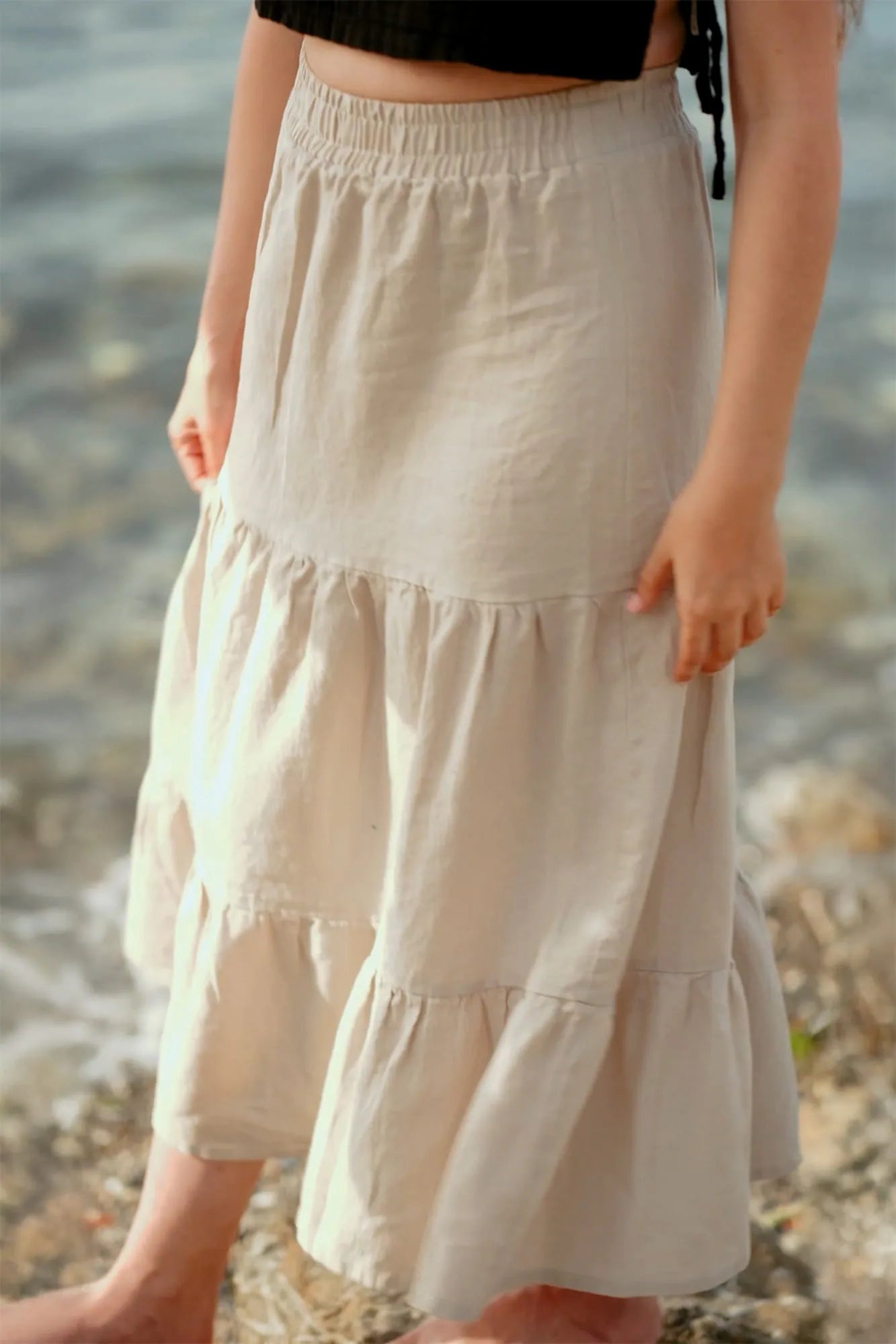 Beige tiered skirt worn by a person standing near water