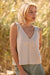 Woman wearing a beige sleeveless linen top in a natural setting