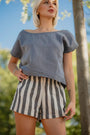 Woman in a gray top and black and white striped linen shorts outdoors — linen-cotton blend, pull-on mini fit