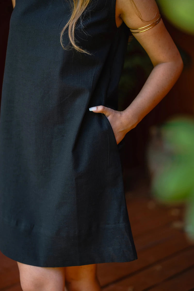 Person wearing a black mini dress with a blurred background