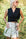 Woman in a black sleeveless tie front linen wrap vest top and white skirt in a natural setting — European Flax® linen
