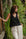 Woman in black sleeveless v neck Linen Wide Strap Tank Top and white pants standing in a natural setting