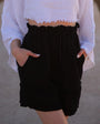 Woman in a white cropped top and black cotton gauze shorts — soft crinkled double gauze cotton, high waist