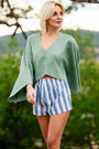 Woman in a green top and blue striped linen shorts outdoors — linen-cotton blend, pull-on mini fit