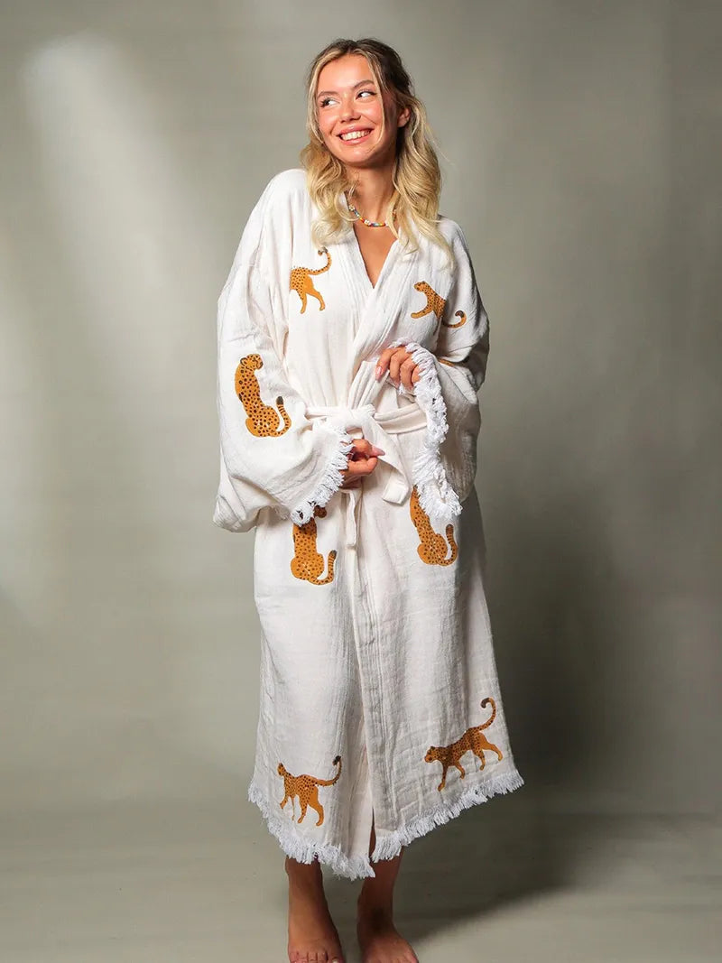 Woman wearing a white robe with tiger patterns on a gray background