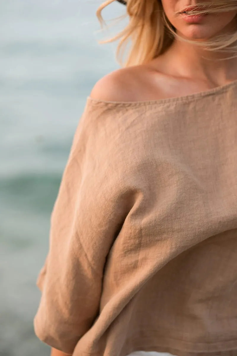 Person wearing a brown natural linen blouse top with a blurred background