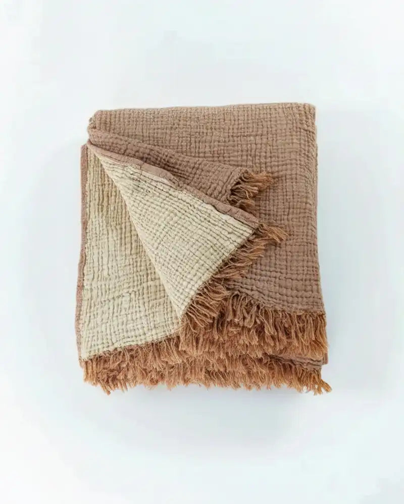 cinnamon Brown muslin blanket with frayed edges on a white background