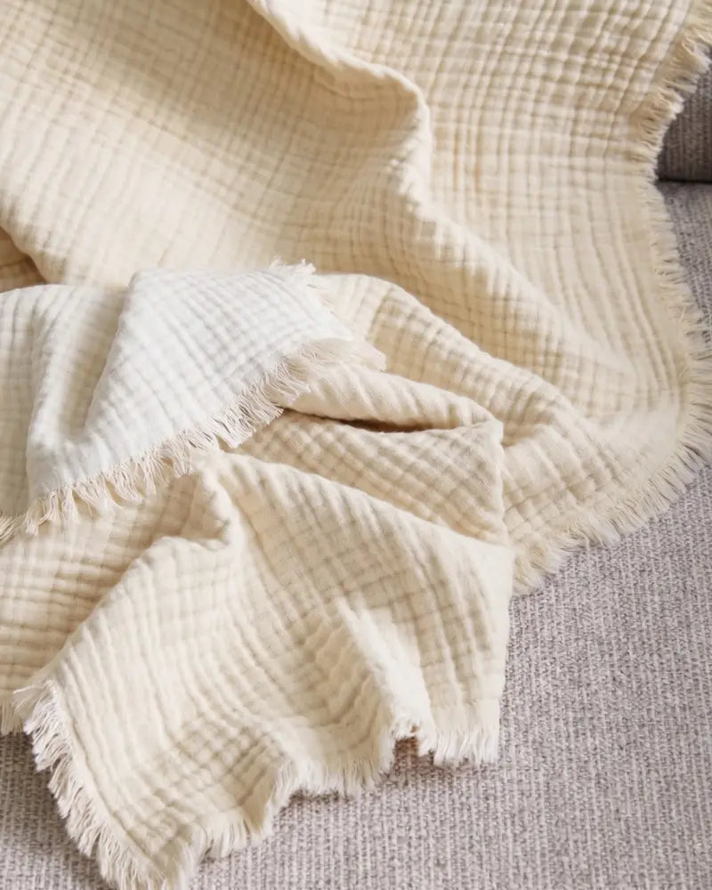 Close-up of a muslin beige blanket on a surface