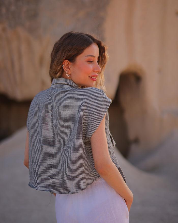 Back view of sleeveless striped cropped shirt showing button-down design