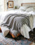 Dark grey muslin throw blanket on a white bed — breathable 4-layer OEKO-TEX cotton gauze
