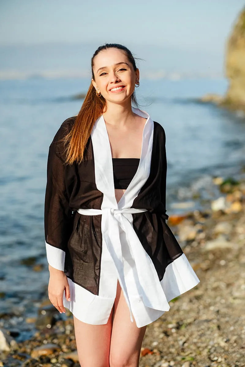 Woman standing on a beach wearing a black and white beach Cover Up.