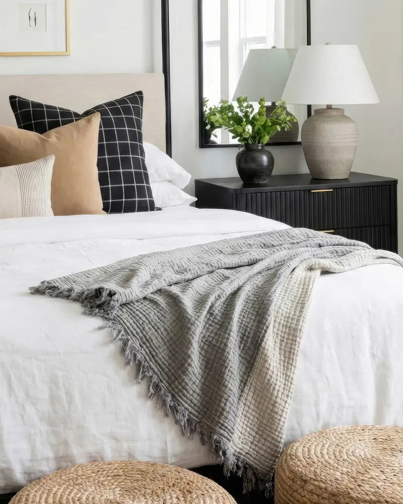 Cozy bedroom with a bed, pillows, and a nightstand with a lamp.