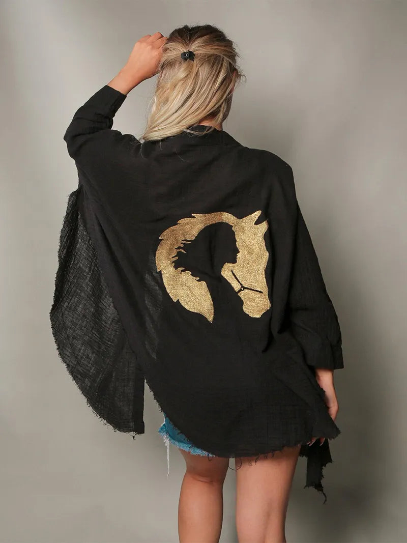 Person wearing a black robe with a gold horse design on the back against a neutral background