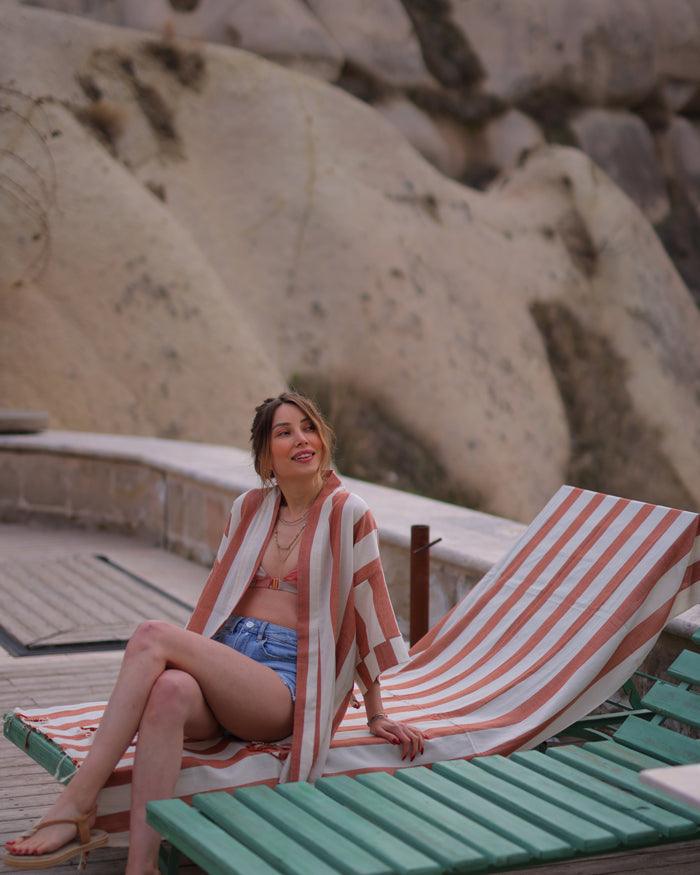 Woman sitting with a lightweight striped travel robe