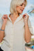 Ivory linen cropped shirt worn with black linen shorts outdoors — soft breathable linen detail
