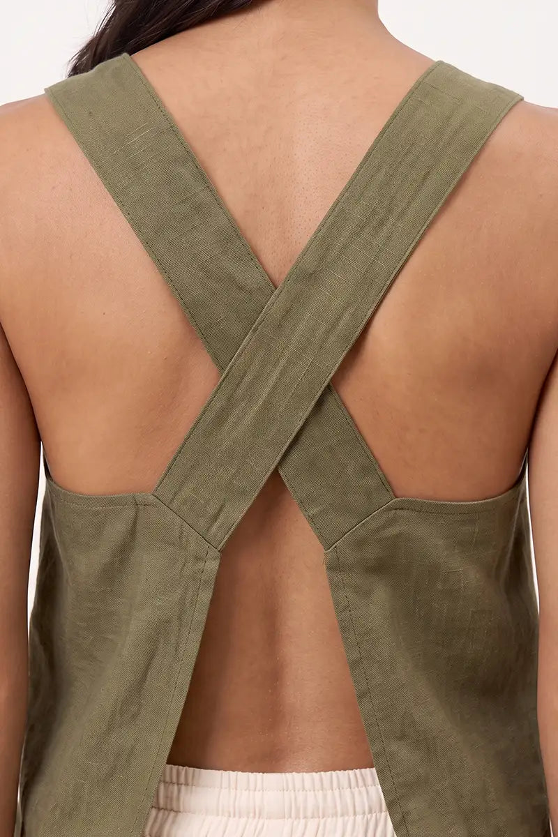 Back view of the olive green wide strap tank top showing the apron-style crossed straps and split opening