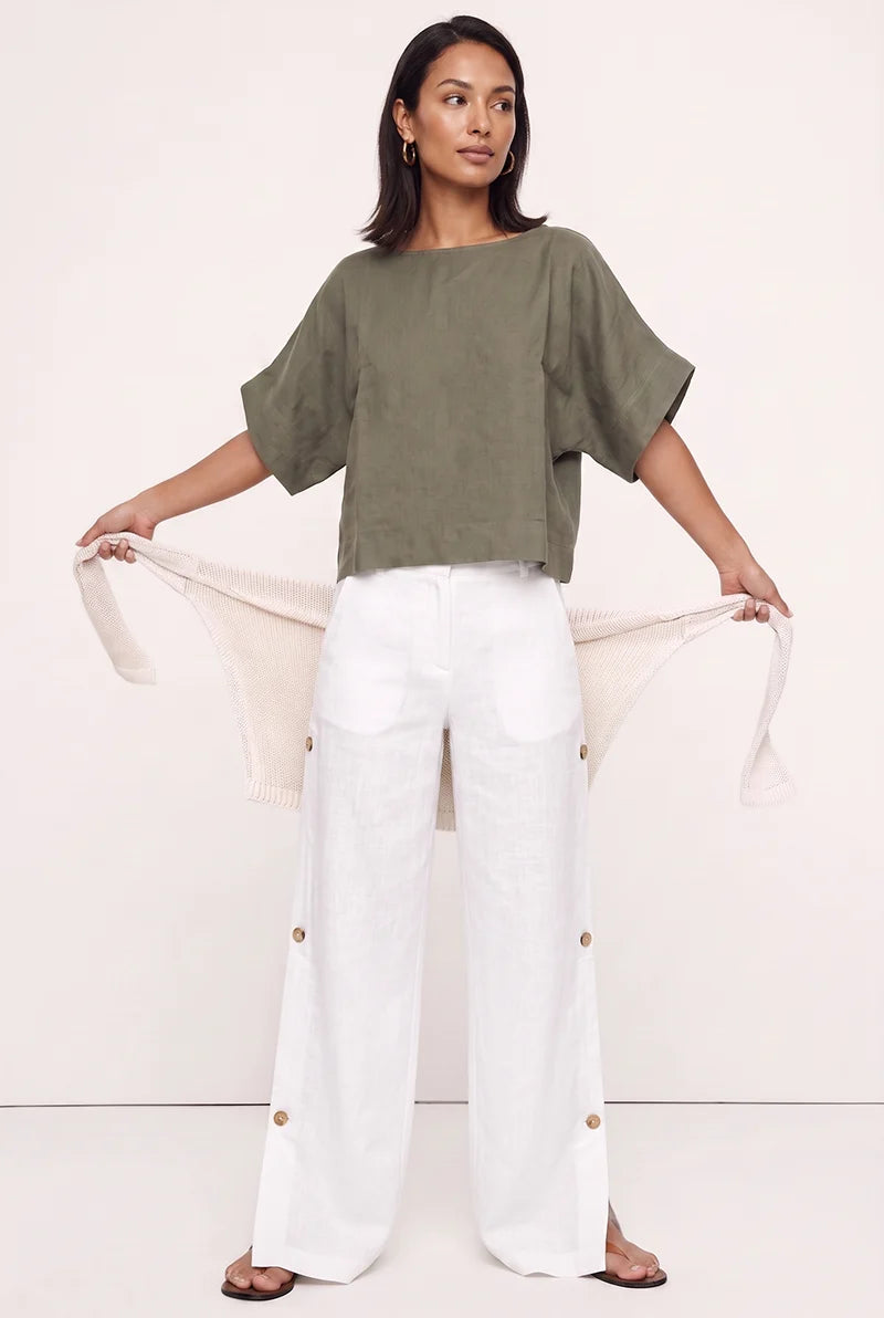 Olive green linen blouse top layered with an open beige cardigan and white wide-leg pants