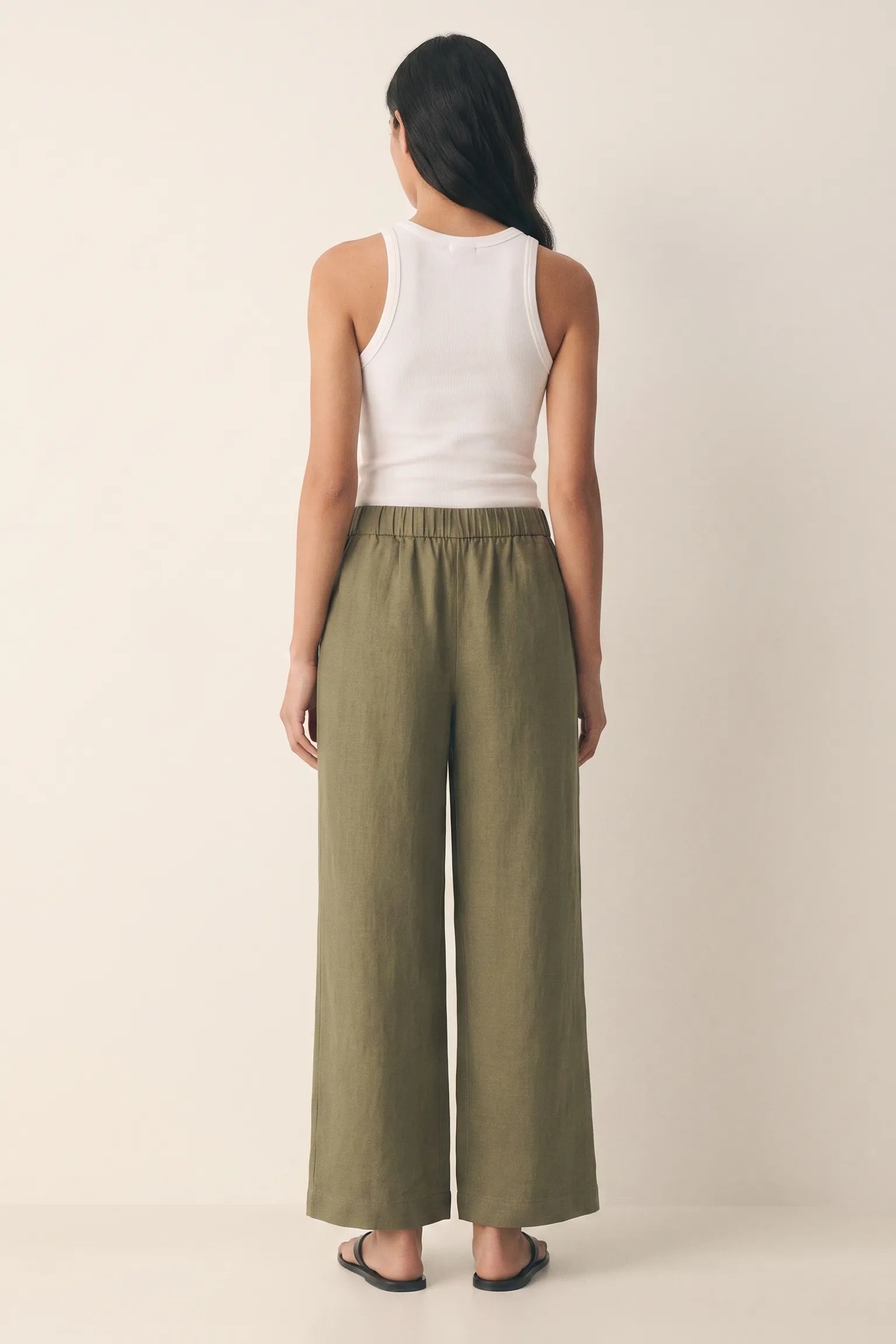 Olive green linen wide leg pants showing the flowing wide-leg drape and side pockets