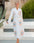 Woman in a white evil eye bathrobe with a geometric eye print in orange and blue  #Color_White/Orange_Eye