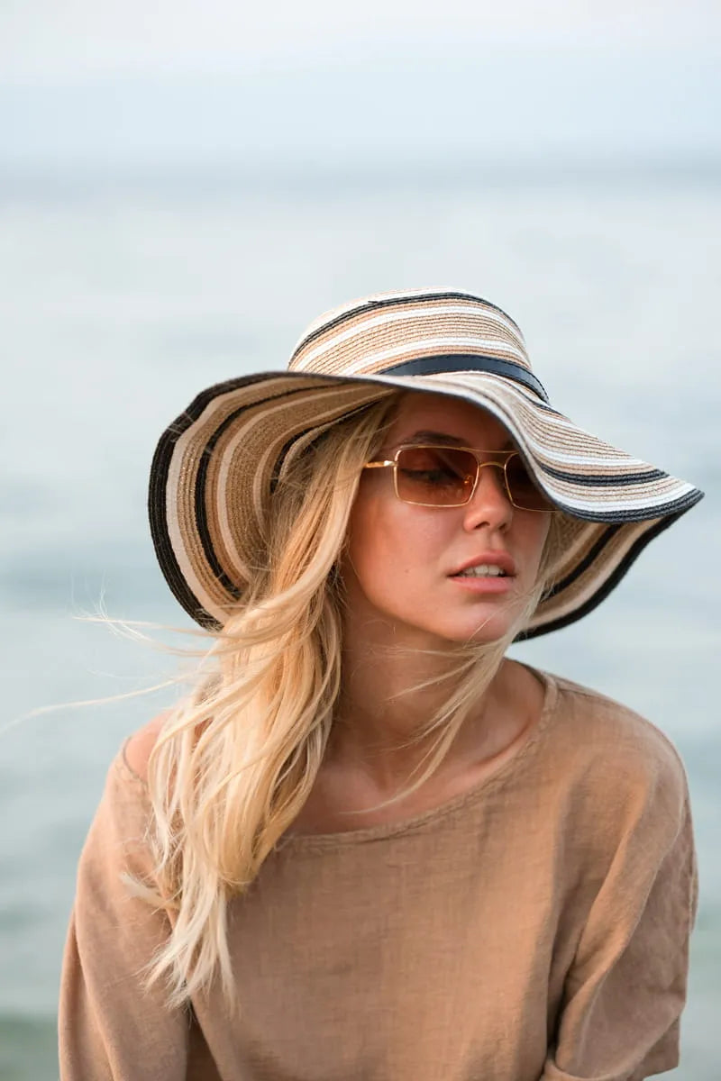 Woman wearing a linen tshirt and sunglasses with a blurred background