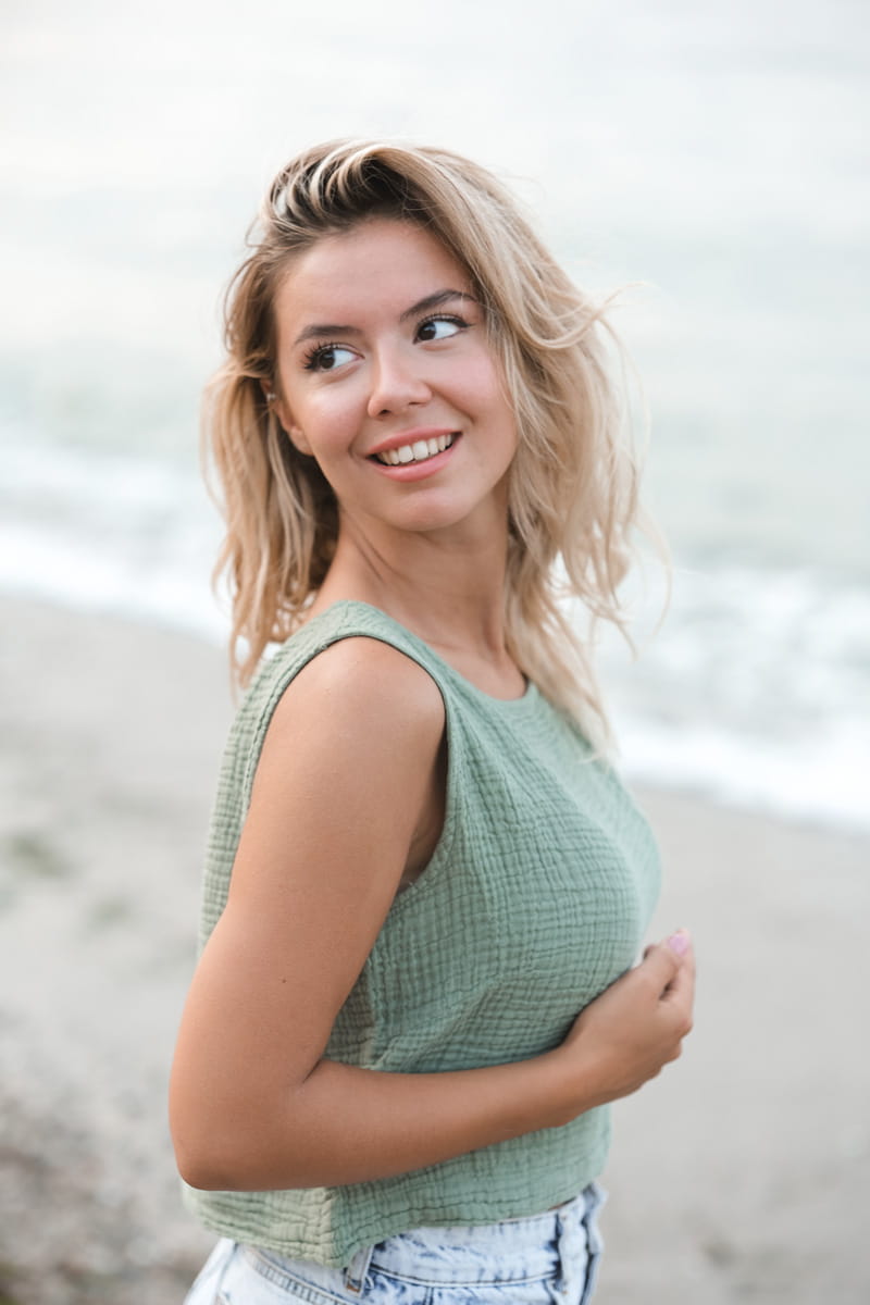 Woman wearing a green sleeveless muslin top with a blurred background