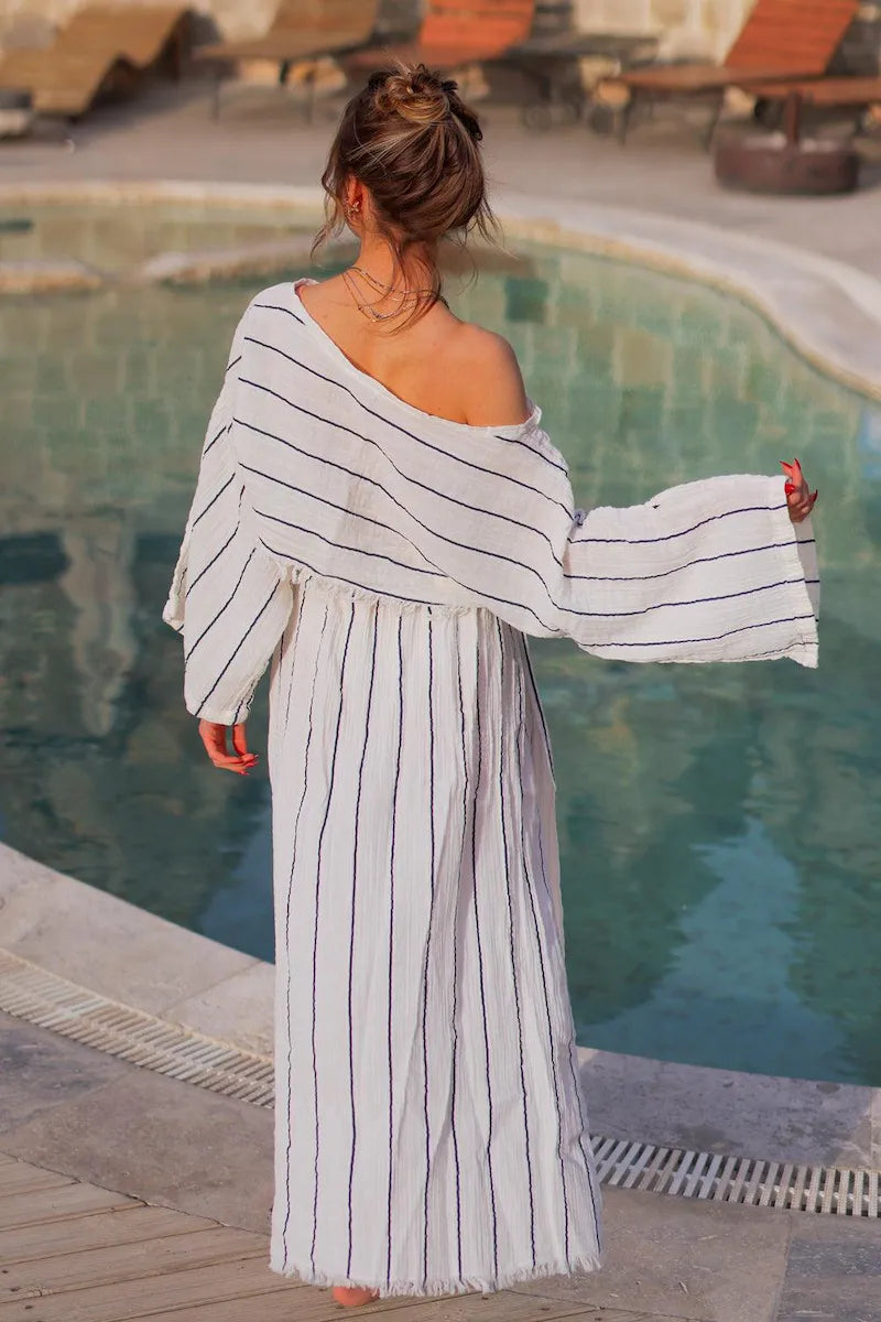 Woman in a striped off the shoudler blouse and skirt by a poolside