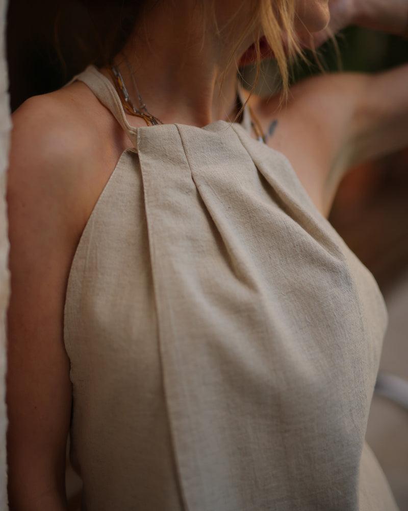 A womana in a stylish linen crop top. and necklace, enjoying a summer day in 