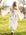 Person wearing a long white cardigan with leopard print designs walking in a grassy field.
