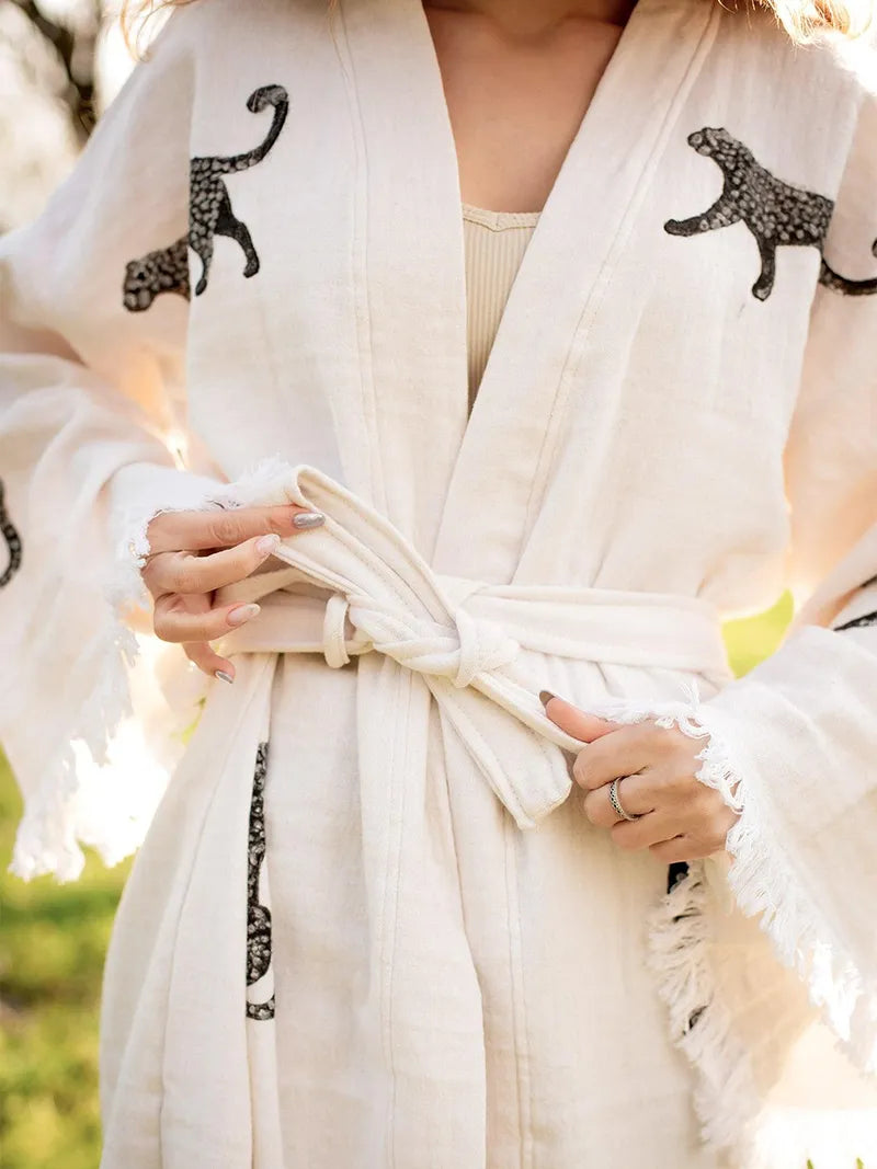 Person wearing a white robe with black tiger designs.