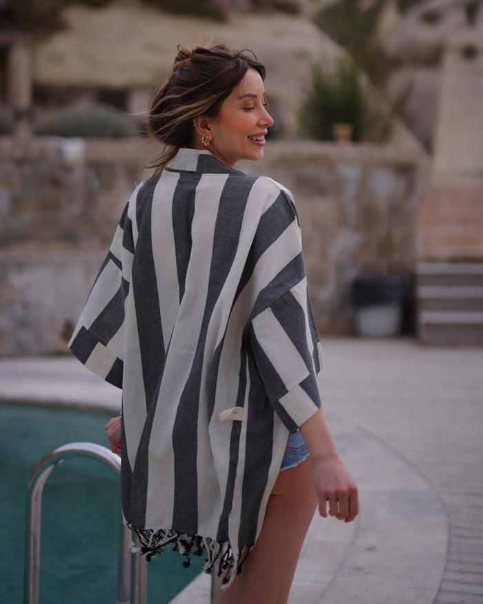 a rear view of woman with black striped turkish bath robe cover up
