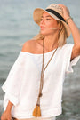 Woman in a straw hat and white linen blouse by the water — soft European Flax linen drape