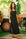 Woman in a black dress standing outdoors with greenery and vintage equipment in the background